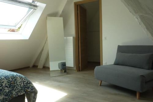 a bedroom with a bed and a chair and a window at Maison rénovée dans le bocage Normand avec jacuzzi in Canisy