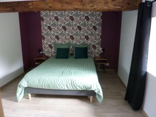 a bedroom with a bed with green sheets and green pillows at Maison rénovée dans le bocage Normand avec jacuzzi in Canisy