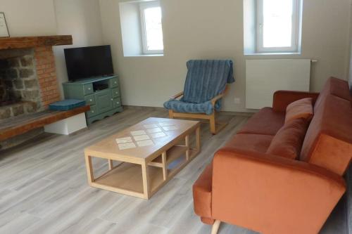 a living room with a couch and a coffee table at Maison rénovée dans le bocage Normand avec jacuzzi in Canisy