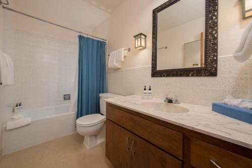 a bathroom with a sink and a toilet and a mirror at JHRL - Slope-side Four Seasons 1 #1 Condo - Walk to Tram in Teton Village