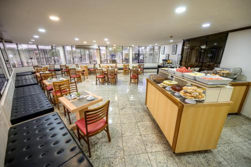 a restaurant with tables and chairs and a buffet at Hotel Dan Inn São Paulo Higienópolis - METRÔ MACKENZIE in Sao Paulo