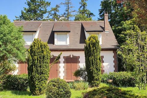 une maison avec deux arbres devant elle dans l'établissement Domaine de Coulonge, à Coulonges-Ardennes