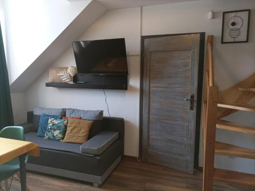 a living room with a couch and a flat screen tv at Ostoja Karkonoska in Podgórzyn