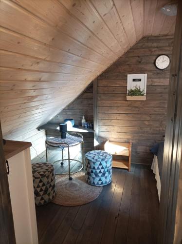 an attic room with a table and a clock at Ostoja Karkonoska in Podgórzyn