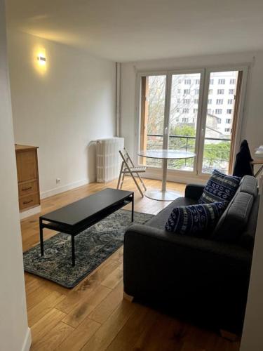 un salon avec un canapé et une table basse dans l'établissement Appartement de standing calme - Paris - Métro 9, à Montreuil