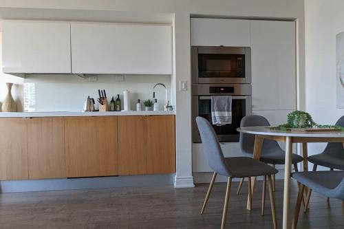 a kitchen with white cabinets and a table with chairs at Lovely 2 Bed Condo in Downtown Toronto in Toronto
