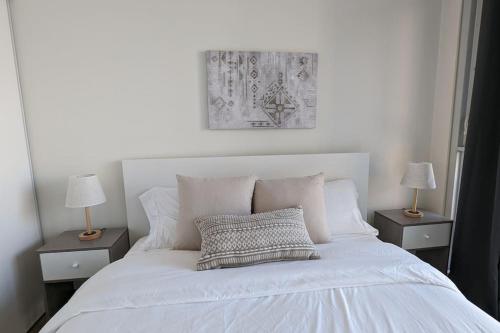 a bedroom with a white bed with two night stands at Lovely 2 Bed Condo in Downtown Toronto in Toronto