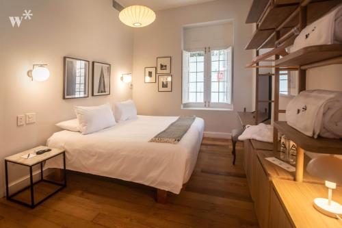 a bedroom with a large white bed and a shelf at Casa Wynwood Barranco in Lima