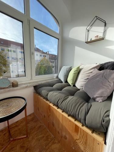 kanapę siedzącą w pokoju z dwoma oknami w obiekcie Zentrale 3-Zimmer-Wohnung in Nürnberg w Norymberdze