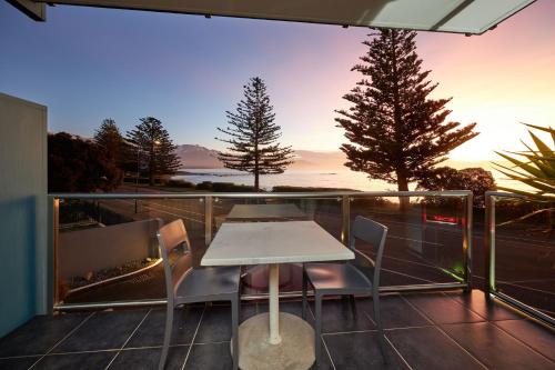 a patio with a table and chairs on a balcony at Waves on the Esplanade in Kaikoura