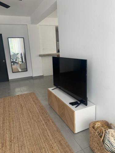 a flat screen tv on a white stand in a living room at SOKZO Miramar in San Juan