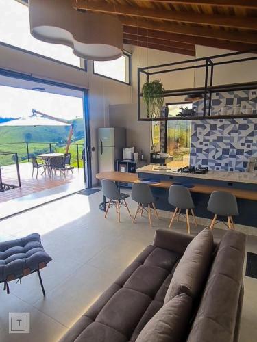 a living room with a couch and a table with chairs at Solarium Mantiqueira - Conforto e vistas incríveis in Itanhandu