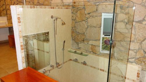 La salle de bains est pourvue d'une douche avec une porte en verre. dans l'établissement Casa de Piedra. Tequesquitengo, à Tequesquitengo