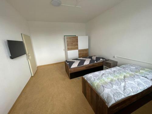 a bedroom with two beds and a tv in it at Rent a Room Amstetten in Amstetten
