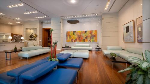 a waiting room with couches and tables in a building at Hotel Arya BW Premier Collection in Miami