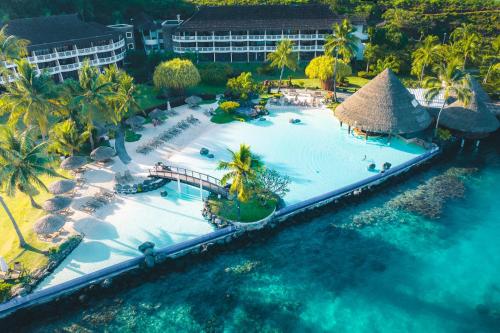 a beach scene with a pool and a large building at InterContinental Tahiti Resort & Spa, an IHG Hotel in Faaa