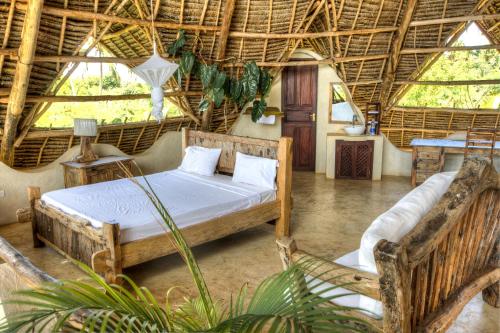 a bedroom with two beds in a room with windows at Milele Villas in Potoa