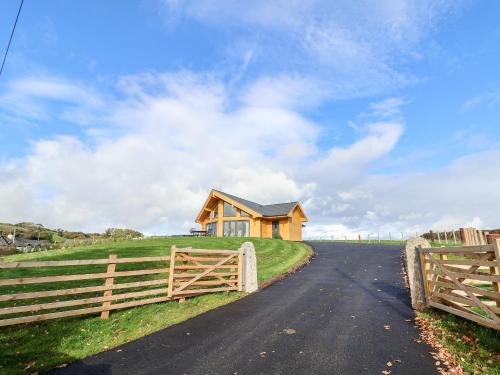a house on a hill with a fence and a road at Pen Bryn in Ruthin