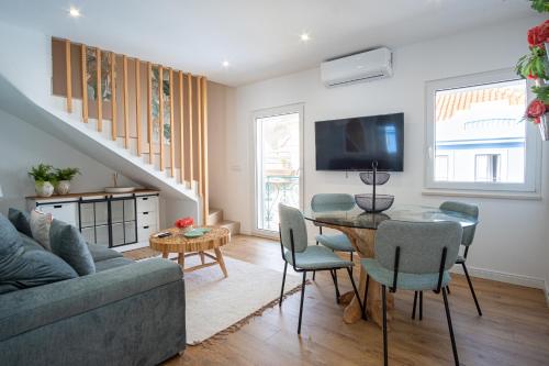 a living room with a couch and a table with chairs at Feel Nazaré - Saudade 57 in Nazaré
