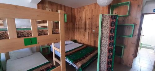 two bunk beds in a room with wooden walls at Atlantic Sal Hostel in Santa Maria