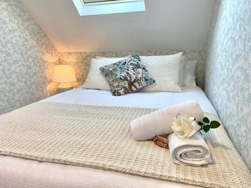 Un dormitorio con una cama blanca con una toalla. en PRECiOSO ÁTICO, en Majadahonda