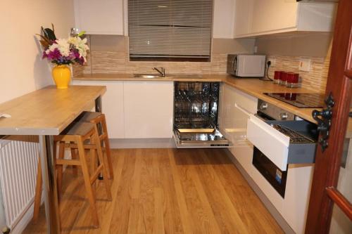 a kitchen with white cabinets and a wooden counter top at Entire -4 Bedrooms Detached House with Driveway in Nottingham