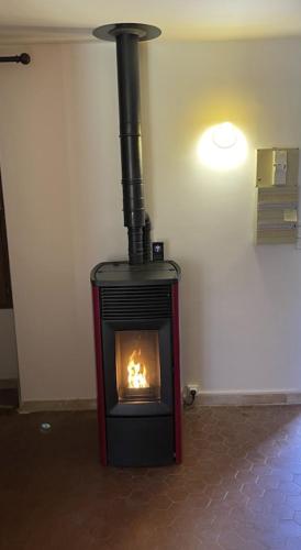 a fireplace in the corner of a room at La grande maison dans la prairie in Caille