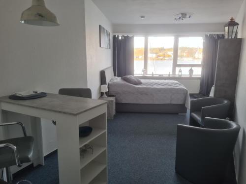 um quarto com uma cama, uma secretária e uma mesa em Ferienwohnung ADARO em Schleswig