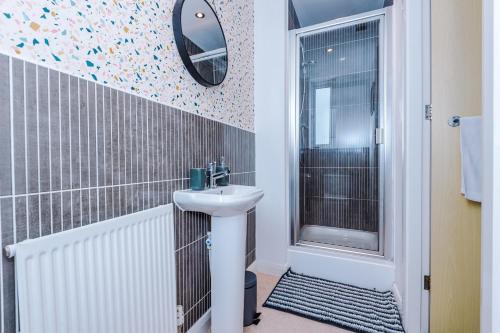 a bathroom with a sink and a mirror at Townhouse 5mins to City Centre and Etihad - Free Secure Parking in Manchester