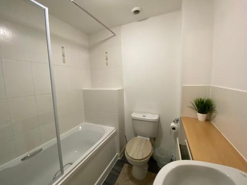 a bathroom with a tub and a toilet and a sink at Wellingborough Cosy Hub in Harrowden