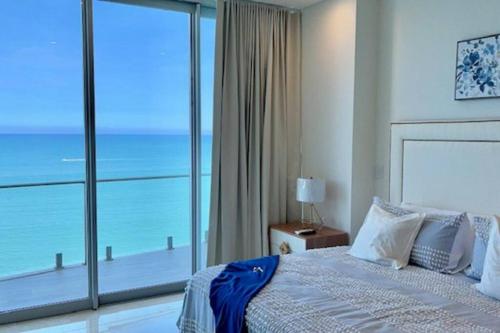 a bedroom with a bed with a view of the ocean at CONDO DE LUJO EN PLAYA ZONA DORADA CAMINO AL MAR in Mazatlán
