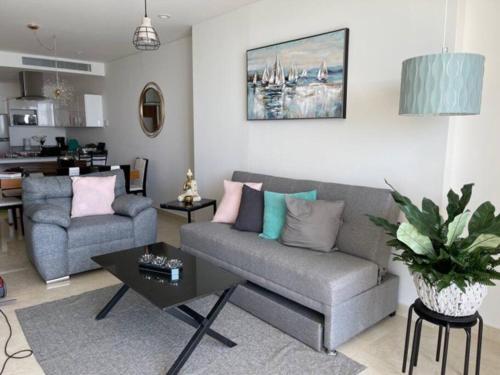 a living room with a couch and a table at CONDO DE LUJO EN PLAYA ZONA DORADA CAMINO AL MAR in Mazatlán