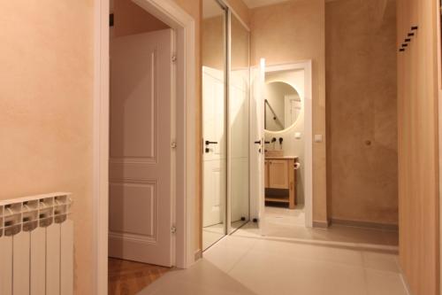 a hallway with a mirror and a white door at Beige Apartment in Sarajevo