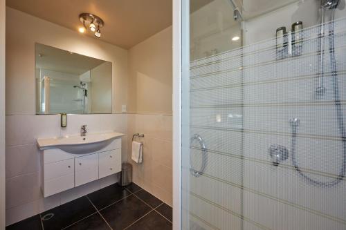 a bathroom with a glass shower and a sink at Waves on the Esplanade in Kaikoura
