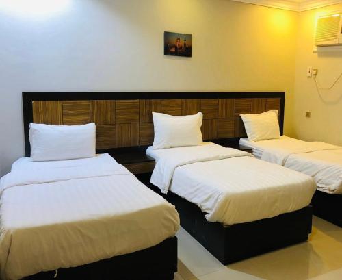 a room with two beds with white sheets at Afaq Al Raha in Khamis Mushayt
