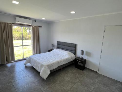 a bedroom with a bed and a large window at Chalet La Gringa in San Rafael