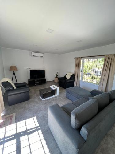 a living room with a couch and a tv at Chalet La Gringa in San Rafael
