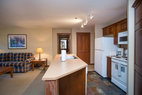 Il comprend un salon et une cuisine équipée d'appareils électroménagers blancs. dans l'établissement 3205 - Two Bedroom Standard Powderhorn Lodge condo, à Solitude