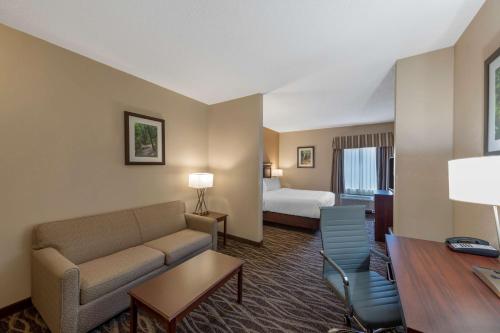 a hotel room with a couch and a bed at Best Western Plus Russellville Hotel & Suites in Russellville