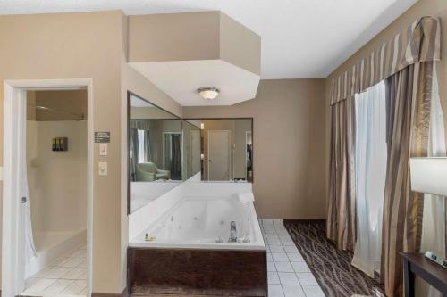 a large bathroom with a tub and a large mirror at Best Western Plus Russellville Hotel & Suites in Russellville