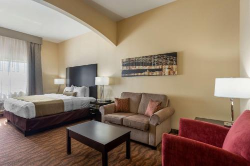 ジェファーソンシティにあるBest Western Plus Capital Innのベッド、ソファ、椅子が備わるホテルルームです。