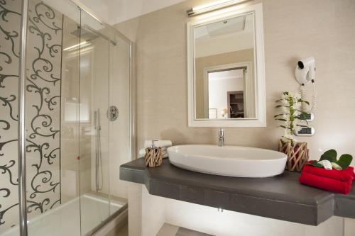 a bathroom with a sink and a glass shower at Demetra Hotel in Rome