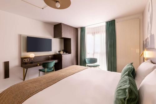a hotel room with a bed and a desk and a tv at Best Western Plus l'Artist Hotel in Tours