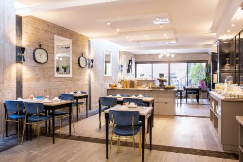 a restaurant with tables and chairs and a kitchen at Best Western Plus l'Artist Hotel in Tours