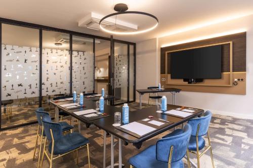 a conference room with tables and chairs and a flat screen tv at Best Western Plus l'Artist Hotel in Tours