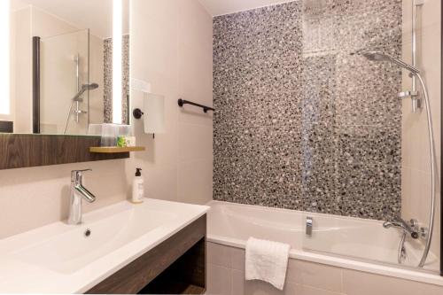 a bathroom with a tub and a sink and a shower at Best Western Plus l'Artist Hotel in Tours