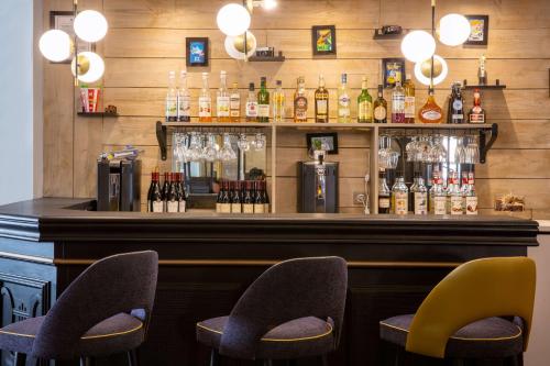 a bar with chairs and bottles of alcohol at Best Western Plus l'Artist Hotel in Tours