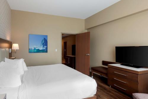 a hotel room with a bed and a flat screen tv at Best Western Plus St. John's Airport Hotel and Suites in St. John's