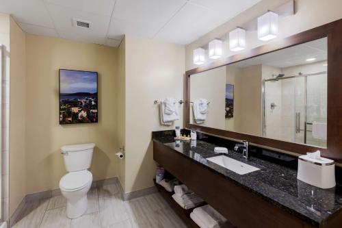 W łazience znajduje się umywalka, toaleta i lustro. w obiekcie Best Western Plus St. John's Airport Hotel and Suites w mieście St. John's