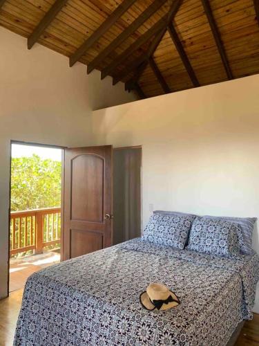 a bedroom with a bed with a hat on it at Lila loft- Private one floor bedroom &free parking in Roatan